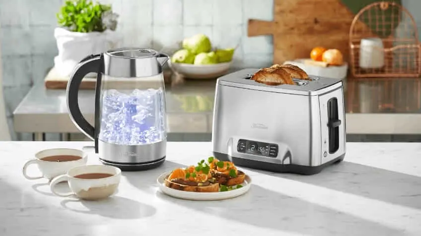 Sunbeam kettle and toaster on kitchen benchtop surrounded by cups of coffee and toast