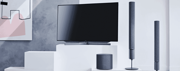 Two tower speakers stand next to a TV