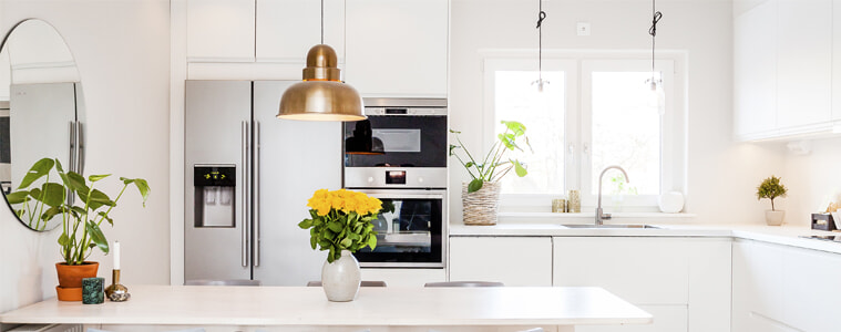 A stainless steel smart fridge in a white kitchen