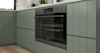 A white and sage green kitchen with Westinghouse kitchen appliances