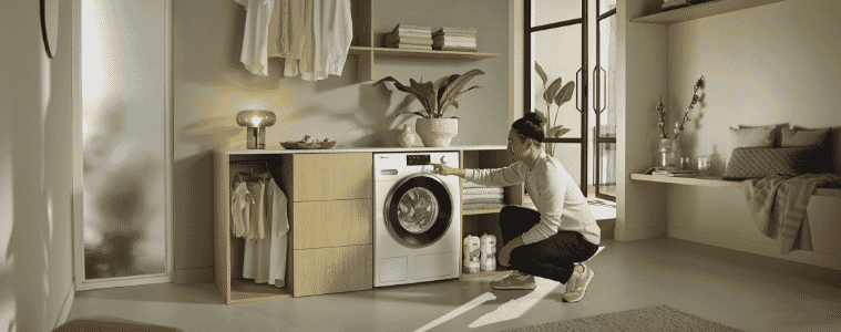 A man putting washing in his Miele washer 