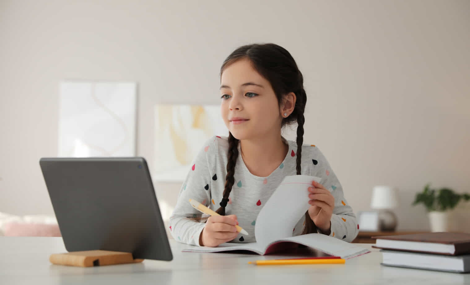 Girl does homework at home from a tablet 