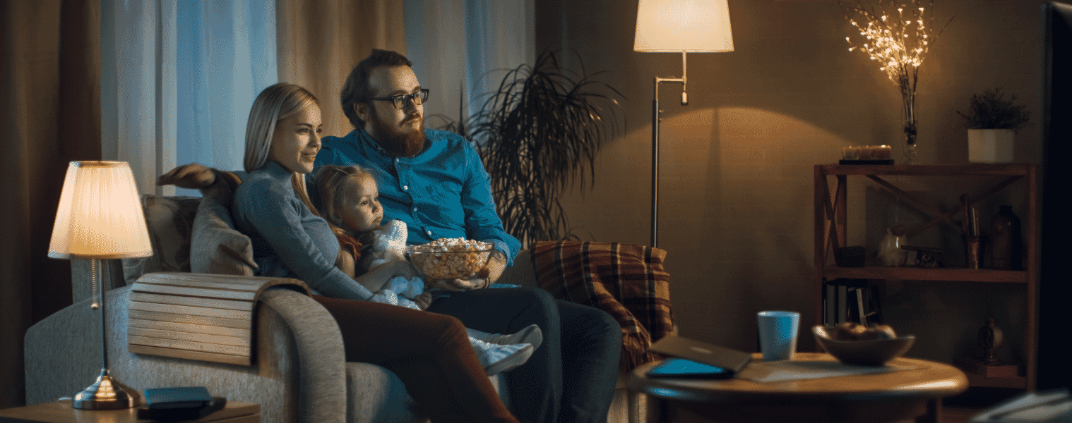 A family watching TV while relaxing on the sofa at home