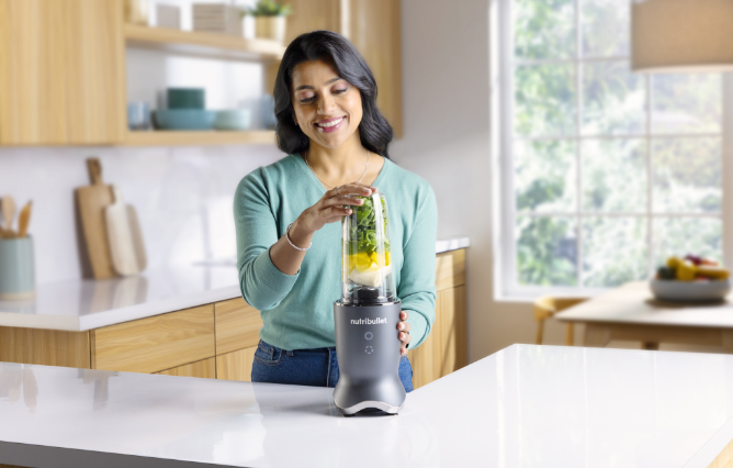 Woman blending Nutribullet blender quietly in her kitchen. 