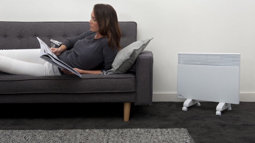 Woman sitting on couch next to Noirot Heater