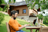 A man uses his laptop outside.
