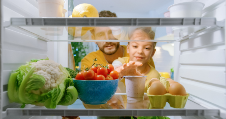 Image of a child and father looking inside a fridge.
