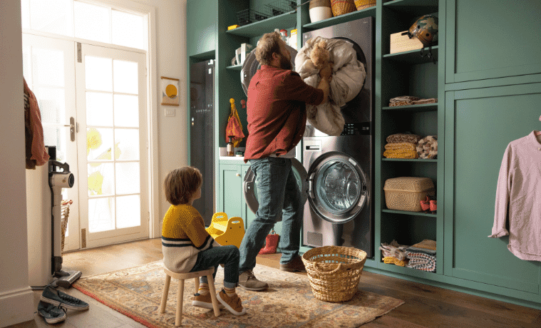 Man and son in eclectic style laundry washing sheets with their LG WashTower 