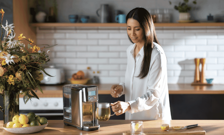 Woman getting hot tea from her water purifier 