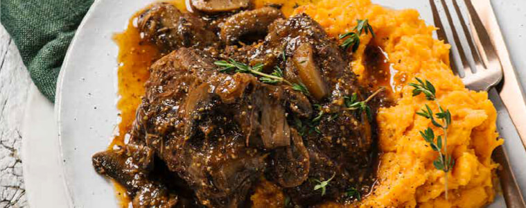 Plate of braised beef and mushrooms on sweet potato mash