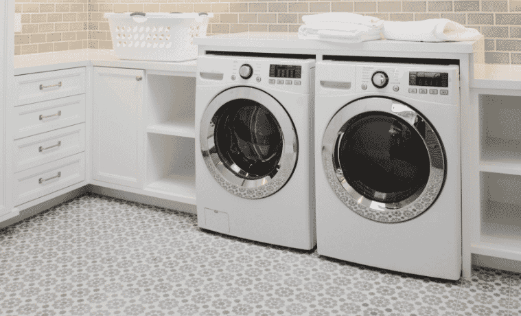 A washing machine and dryer sit sidebyside in a white modern laundry