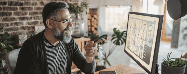 A man attends a video call meeting in his home office