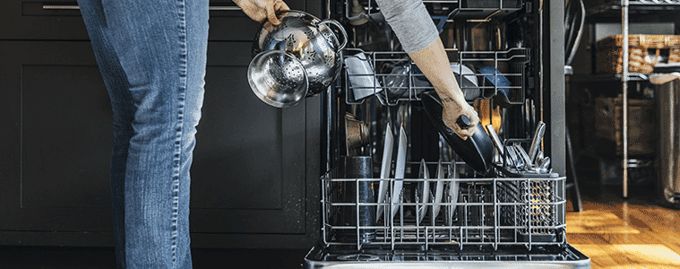 a lady packing the dishwasher 
