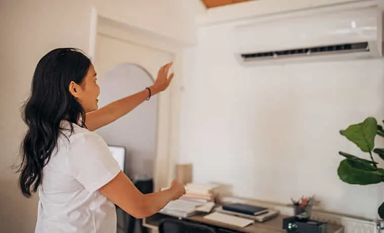Woman operating her new split system in her home office