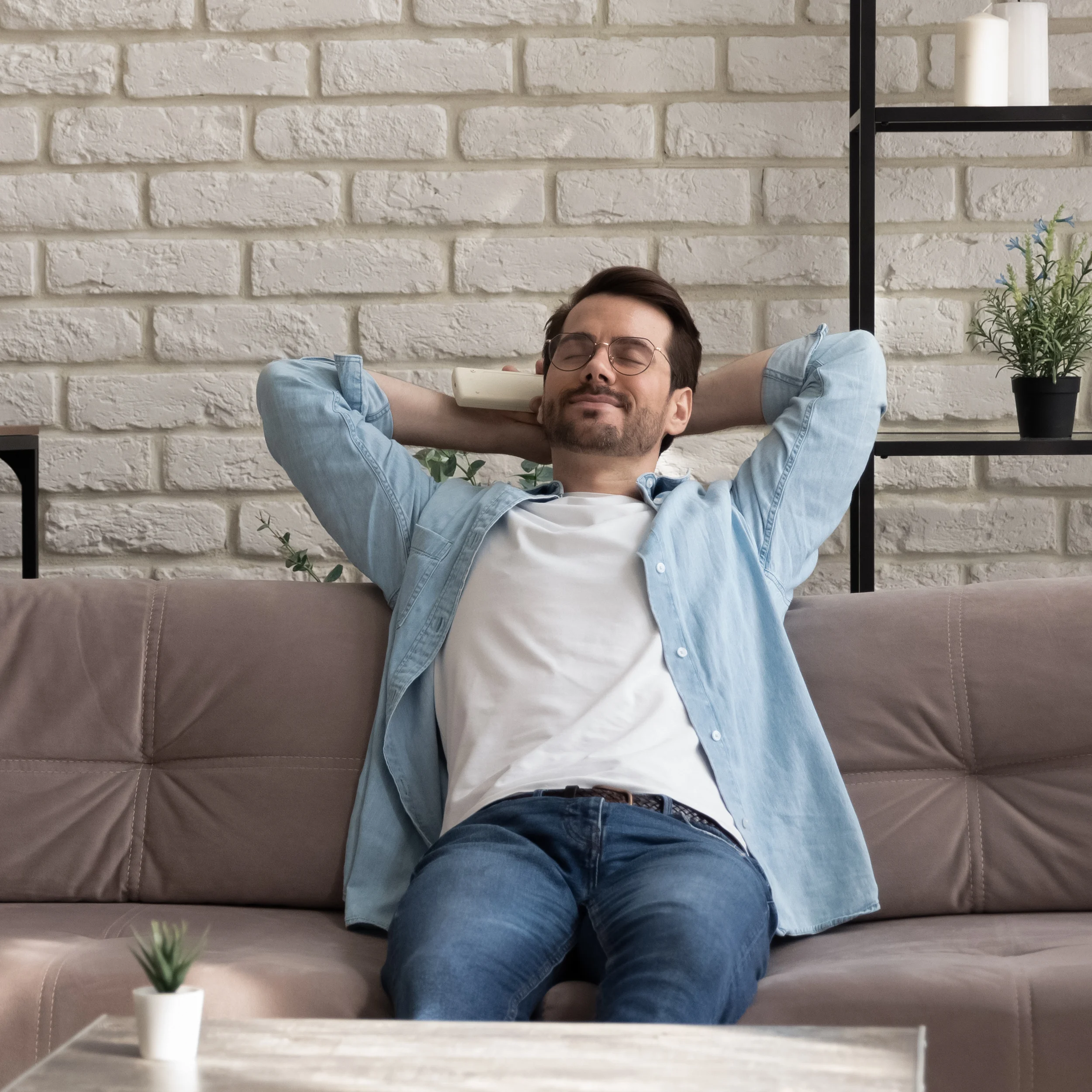 A man uses a remote to adjust the temperature on his air conditioner
