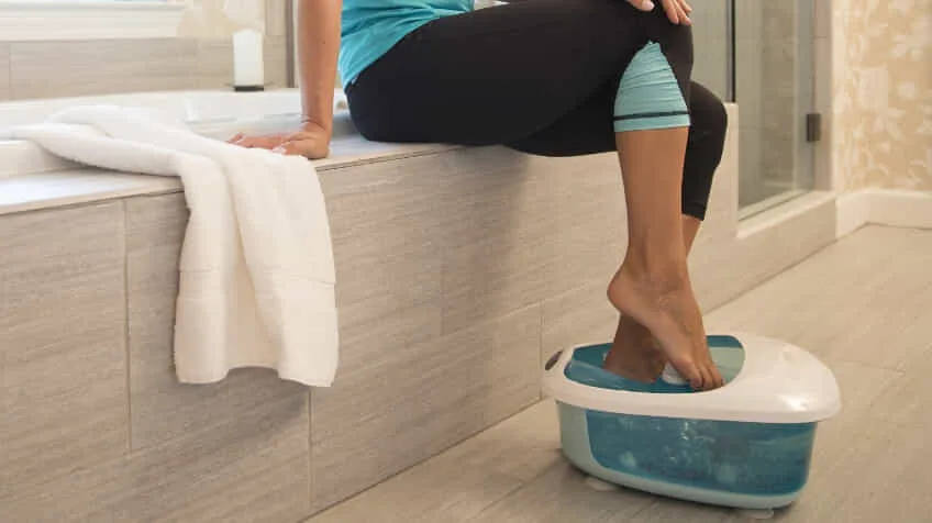 Woman using her Homedics Foot Spa in her modern bathroom