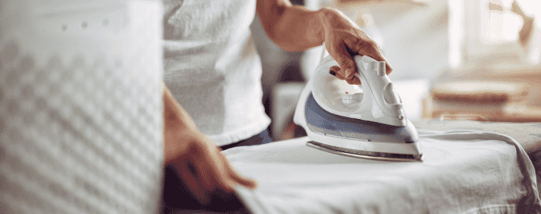 Lady ironing her clothing on her ironing board