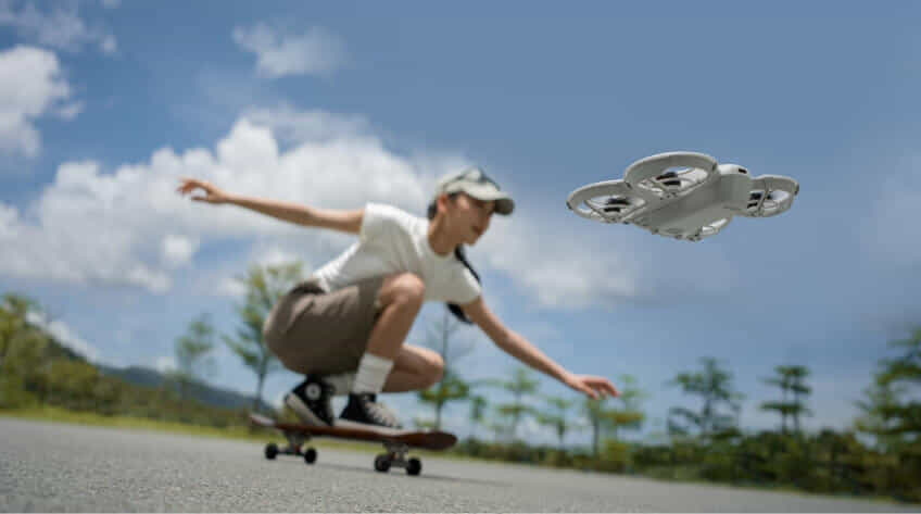 woman skateboards next to DJI Neo drone
