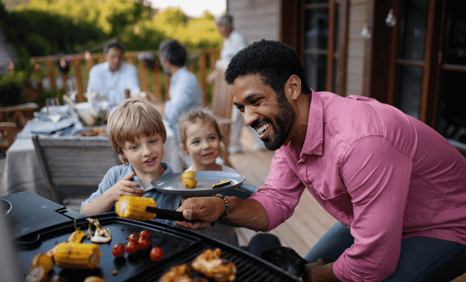 Happily family and friends enjoying barbequed food in their outdoor entertainment area