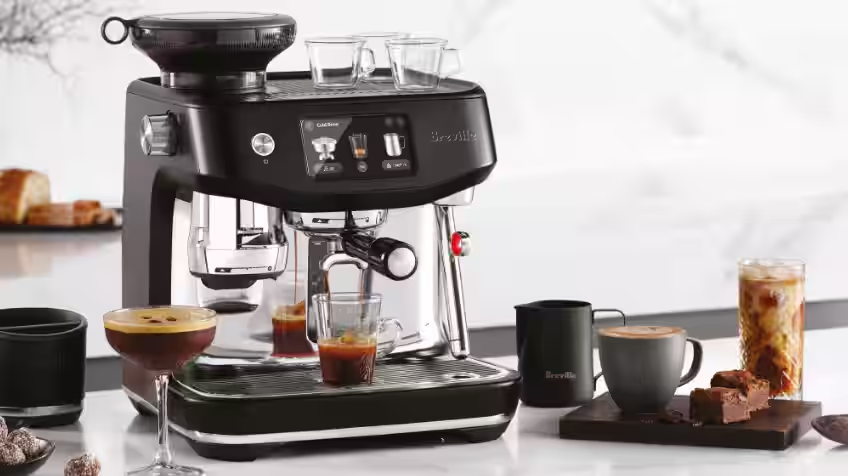 Woman using her own Breville Barista Touch Impress Coffee Machine using touch screen and settings to make her perfect brew  The Good Guys