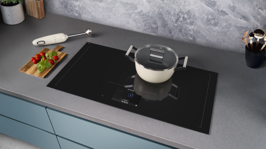 A Smeg induction cooktop in a grey kitchen with a white pot on top of it