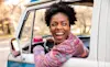 A woman listens to music with a portable speaker in the car as she drives