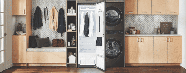 A black drying cabinet next to a matching washer and dryer in a warmtoned timber laundry