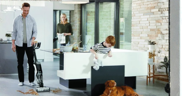 Dad cleaning up mess on the kitchen floor with Bissell Vacuum Cleaner 