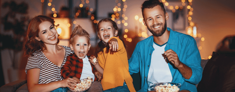 A family sitting together watching a kid friendly halloween movie