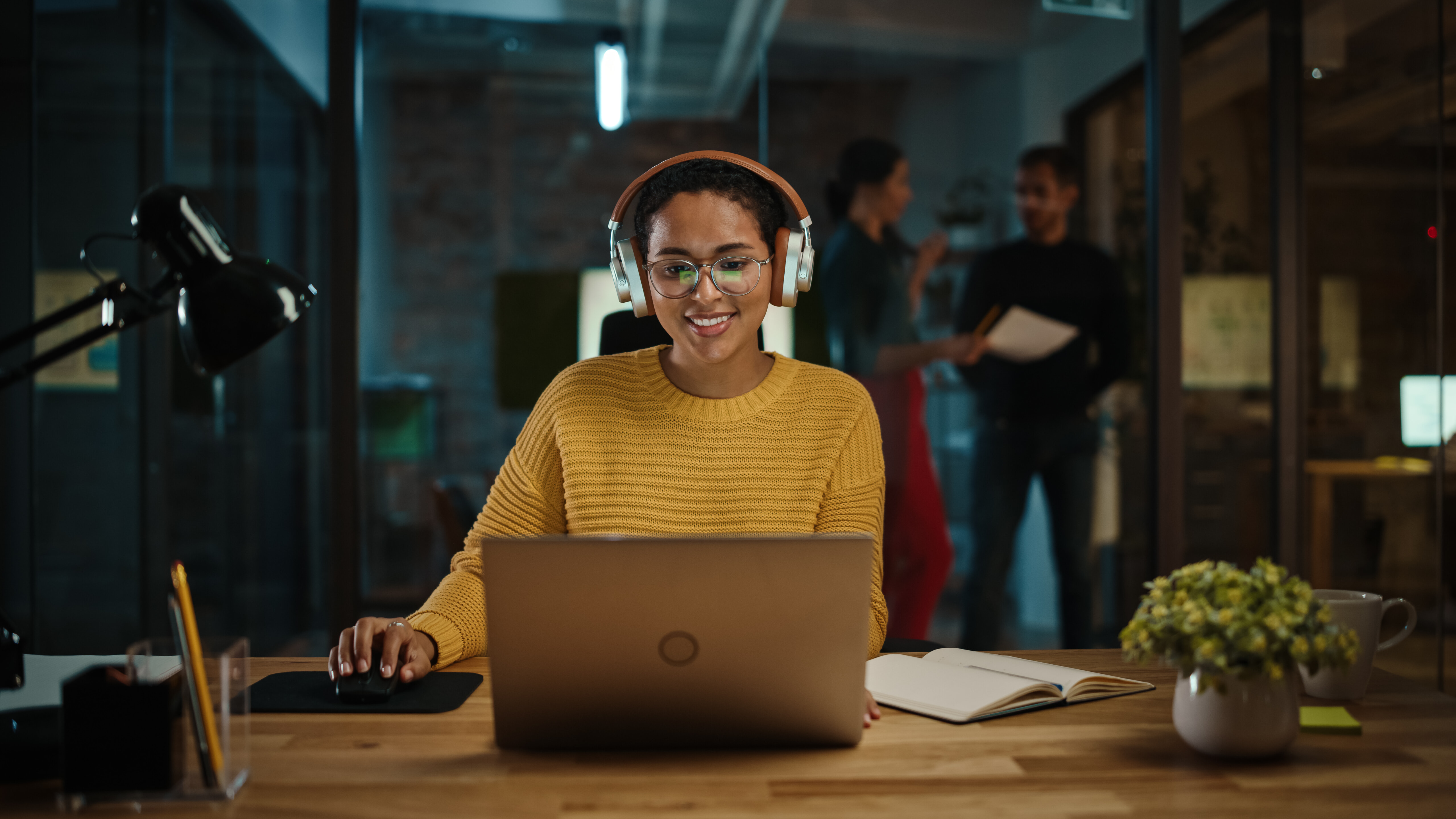 a girl doing work on her computer while listening to music on her headphones 