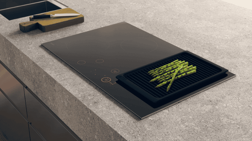 A stylish ASKO induction cooktop being used to grill asparagus