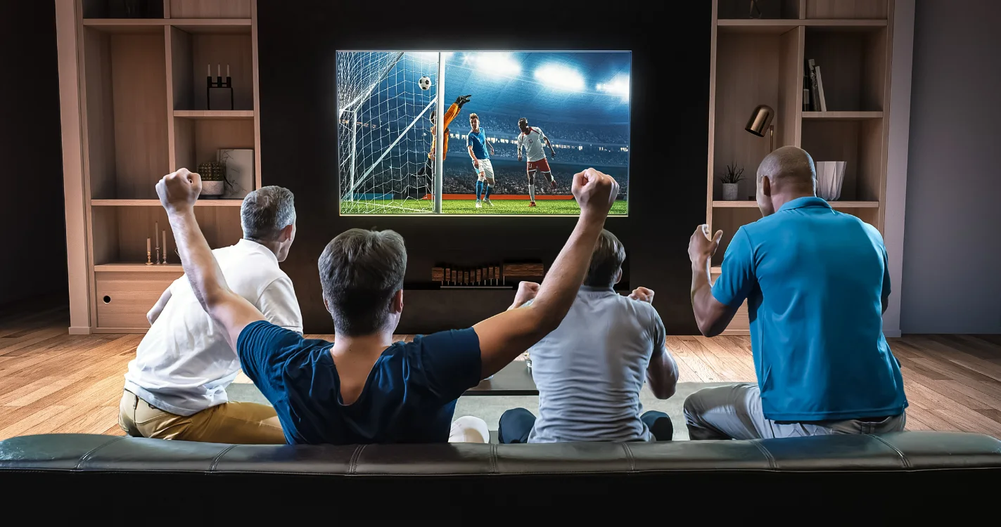 A group of friends watch a soccer game on TV