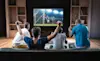 A group of friends watch a soccer game on TV