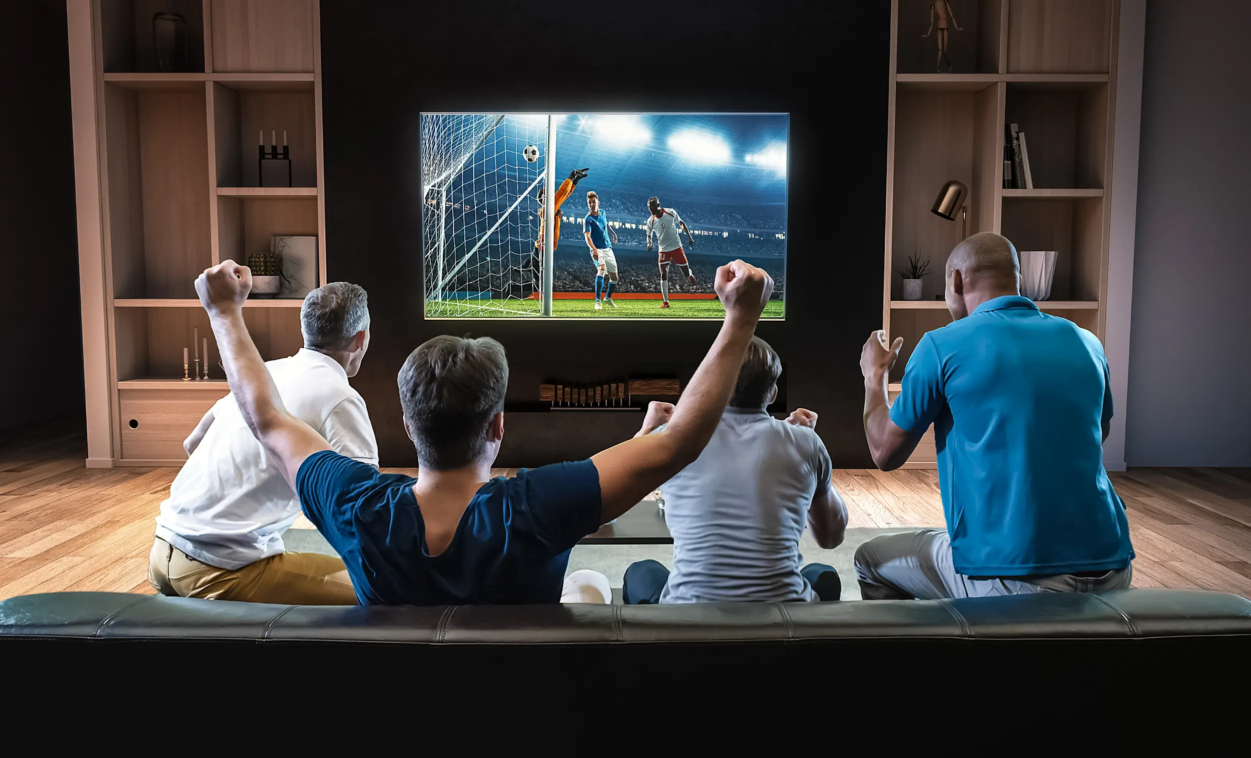 A group of friends watch a soccer game on TV