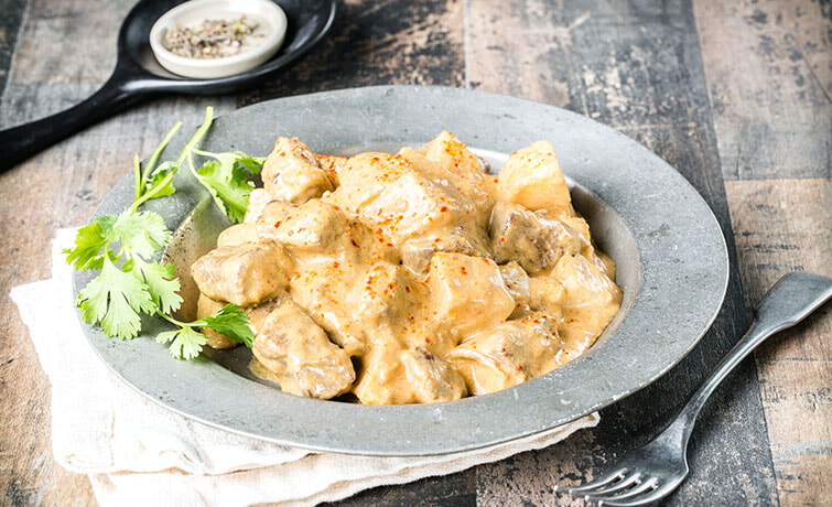 Bowl of Beef Massaman curry on a rustic table
