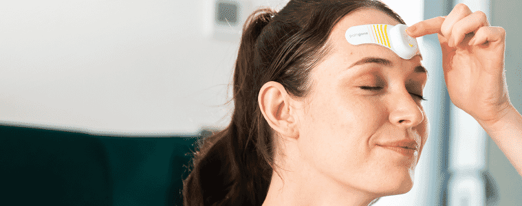 Woman using Paingone Qalm Migrane Relief Device