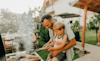 A dad cooking meat on the bbq with his son