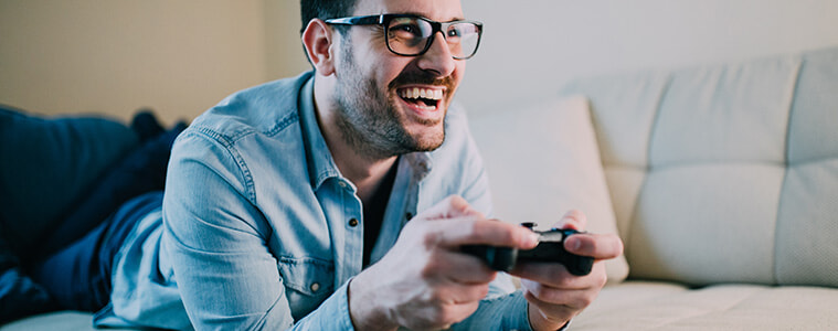 Man lying on the couch playing a video game