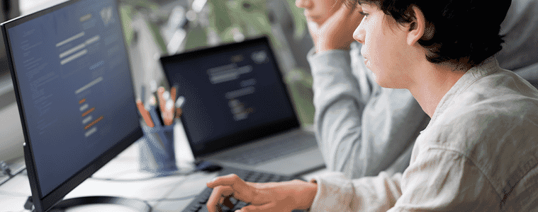 A teen using a monitor connected to a laptop