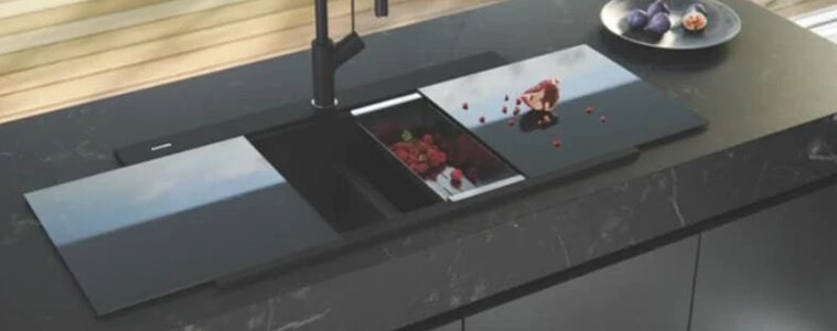 A black moulded granite kitchen sink by Oliveri on a black countertop