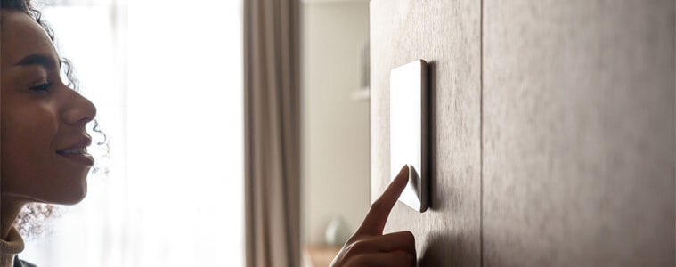 A woman activates her smart home security system