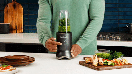 A man blending vegetables in his Nutribullet Ultra 1200 Titanium blender