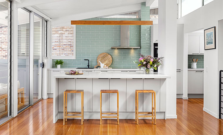 White and timber contemporary kitchen with jade splashback and stainless steel rangehood