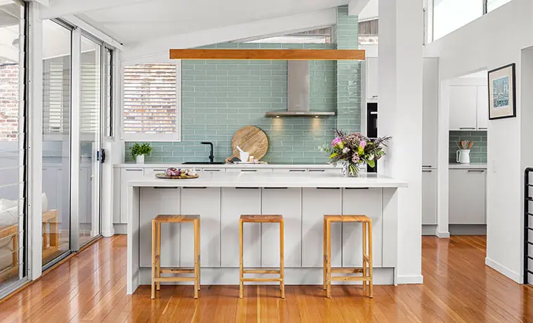 White and timber contemporary kitchen with jade splashback and stainless steel rangehood