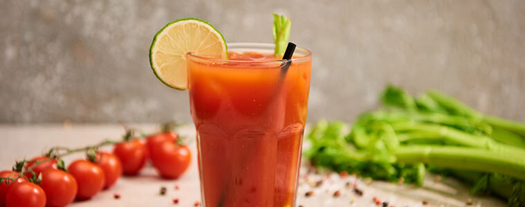 Virgin Bloody Mary cocktail in a tall glass with celery leaf garnish and a black straw
