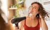 A woman uses a hair dryer to dry her hair