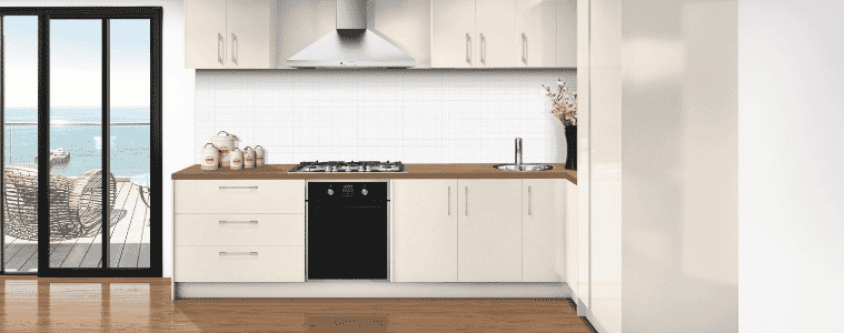 A white flat pack kitchen with timber countertops by the ocean