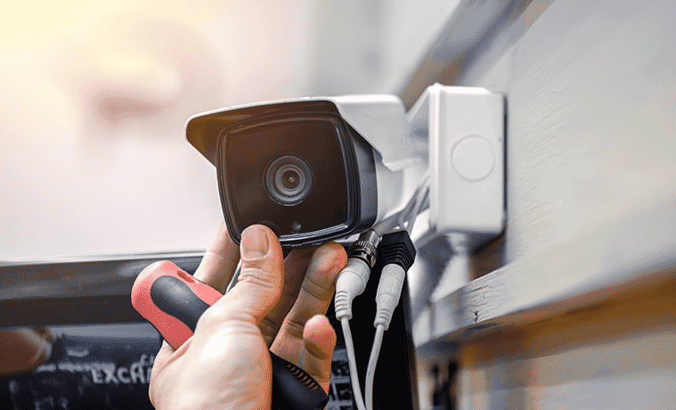 Closeup of a mans hands installing an outdoor security camera