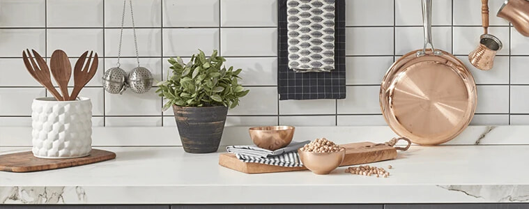 Kitchen utensils on a white benchtop and grey cabinets