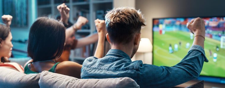 A group of friends watch soccer on their television